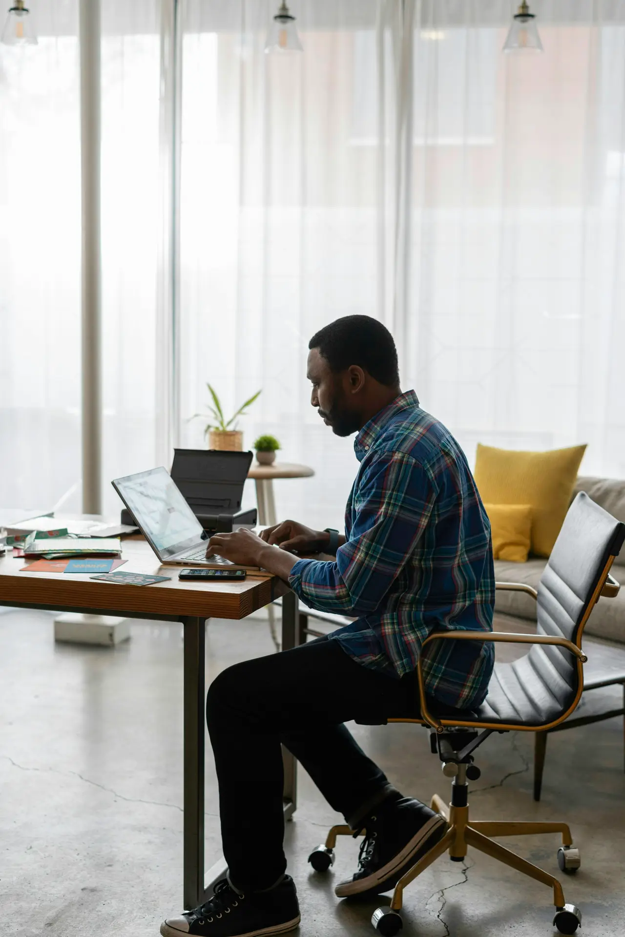 A founder working on a laptop at a desk in a bright home office
